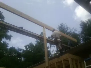 Carpenter setting a ridge beam over a new addition frame — Ice Dam Removal by Roofing Brothers in Centralia