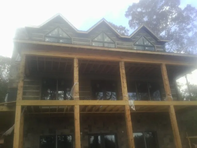 Dormers and porch framing on a large log home under construction — Roof Coating work by our crew in Centralia