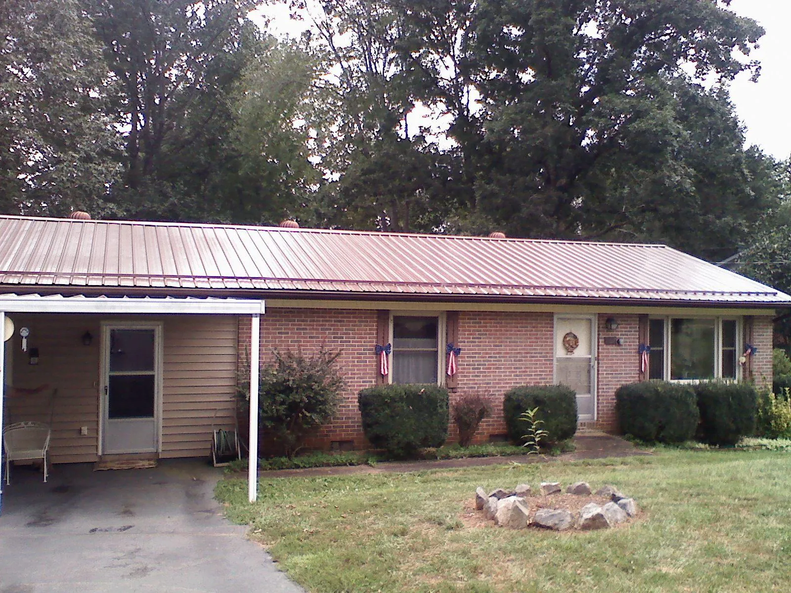 Bronze metal roof and carport on a brick ranch home — Roof Repair work by our crew in Centralia